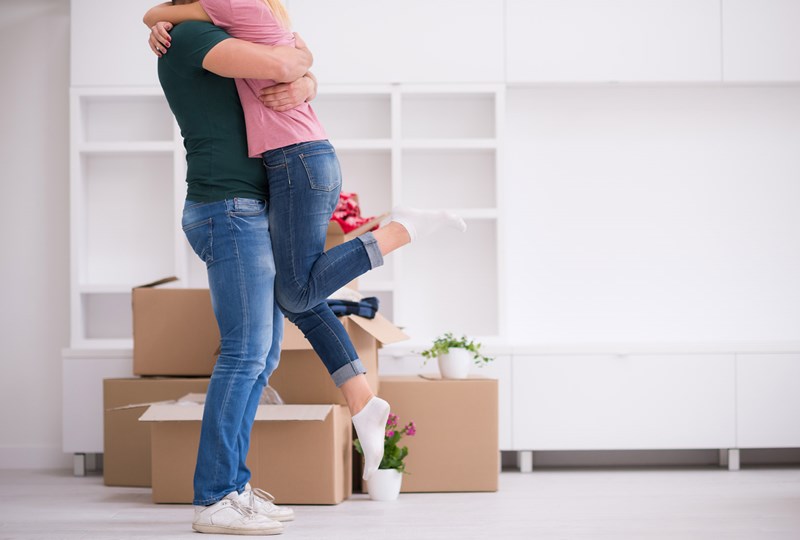 couple hugging in front of packing boxes