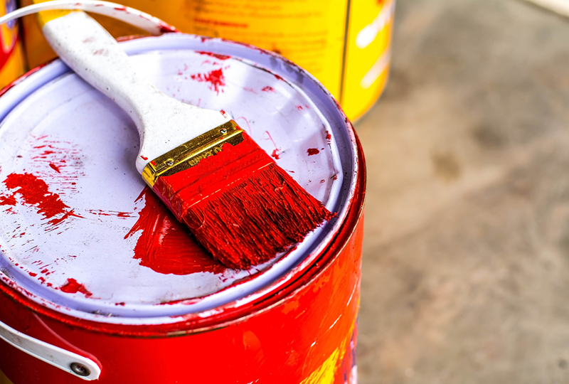red orange paint bucket with brush